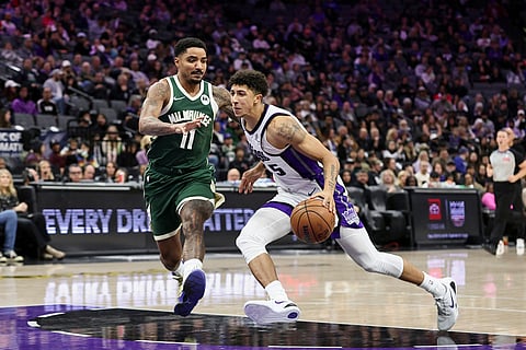 Sacramento Kings guard Nique Clifford (5) drives to the basket with Milwaukee Bucks guard Gary Harris (11) defending during the second half of an NBA basketball game in Sacramento, California.