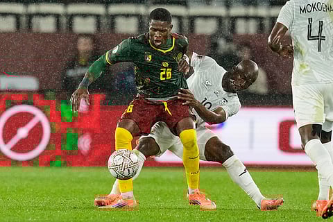 Cameroon's Christian Kofane and South Africa's Nkosinathi Sibisi challenge for the ball during the Africa Cup of Nations round of 16 soccer match between South Africa and Cameroon in Rabat, Morocco.