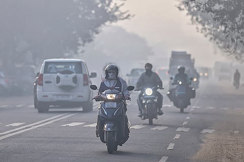 Commuters make their way amid fog on a winter morning, in Jaipur.
