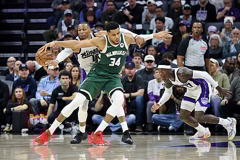 Sacramento Kings guard Russell Westbrook, left, steals the ball from Milwaukee Bucks forward Giannis Antetokounmpo (34) during the second half of an NBA basketball game in Sacramento, California.