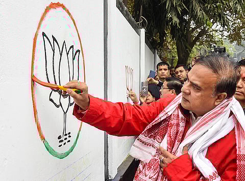 Assam Chief Minister Himanta Biswa Sarma paints on a wall as part of a wall painting drive ahead of the state Assembly elections, in Guwahati.