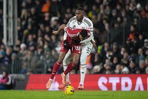 Liverpool's Ryan Gravenberch, left, challenges for the ball with Fulham's Issa Diop during the English Premier League soccer match between Fulham and Liverpool in London.