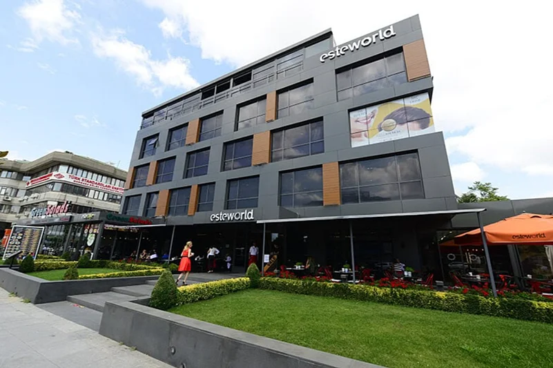 Exterior view of the Esteworld building, a modern multi-story facility with large glass windows