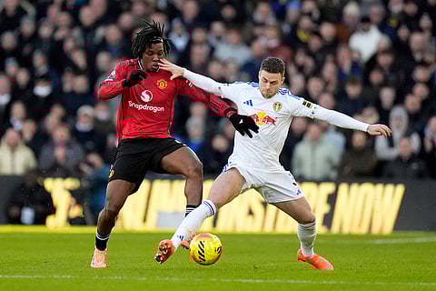 Manchester United's Patrick Dorgu, left, and Leeds United's Gabriel Gudmundsson battle for the ball during the English Premier League soccer match between Leeds United and Manchester United in Leeds, England.