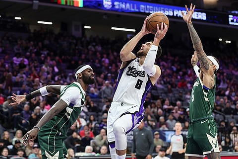 Sacramento Kings guard Zach Lavine (8) goes up for a layup and draws the foul of  Milwaukee Bucks guard Gary Trent Jr., right, during the second half of an NBA basketball game in Sacramento, California.