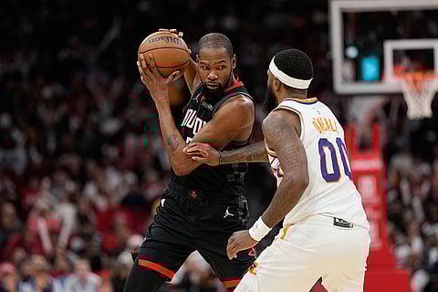 Houston Rockets' Kevin Durant, left, is defended by Phoenix Suns' Royce O'Neale (00) during the second half of an NBA basketball game in Houston. 