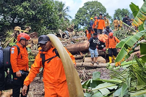 In this photo released by the Indonesian National Search and Rescue Agency (BASARNAS) rescuers and villagers search for victims after flash floods hit Sitaro district of North Sulawesi province, Indonesia. 