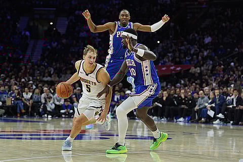 Denver Nuggets' Hunter Tyson (5) tries to get past Philadelphia 76ers' Adem Bona, front right, and Tyrese Maxey, top, during the second half of an NBA basketball game in Philadelphia.