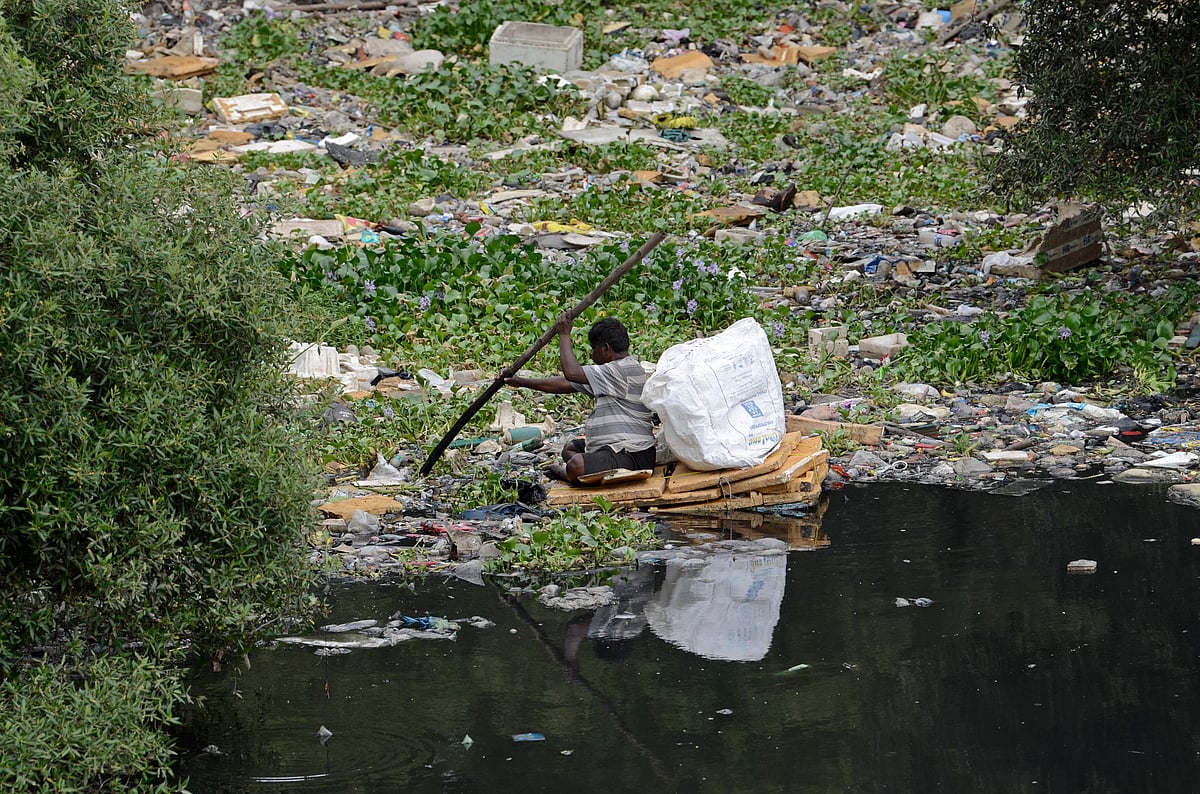 A man paddles a makeshift raft made of thermocol sheets through the polluted waters of the Mithi River in Mumbai, India, on July 1, 2025. The river, which flows through the city s industrial and residential zones, remains heavily contaminated due to untreated sewage and solid waste dumping, posing serious health and environmental risks. - IMAGO / NurPhoto
