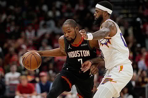 Houston Rockets' Kevin Durant (7) is defended by Phoenix Suns' Royce O'Neale during the second half of an NBA basketball game in Houston. 