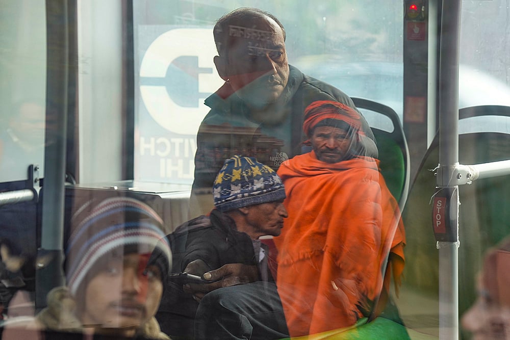 Passengers commute by bus on a cold winter morning, in New Delhi. - | Photo: PTI/Shahbaz Khan