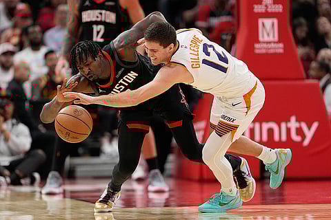 Phoenix Suns' Collin Gillespie (12) tries to steal the ball from Houston Rockets' Dorian Finney-Smith during the second half of an NBA basketball game in Houston.