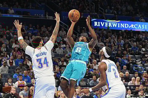 Charlotte Hornets guard Collin Sexton (8) goes up to shoot over Oklahoma City Thunder guards Kenrich Williams (34) and Shai Gilgeous-Alexander (2) during the second half of an NBA basketball game, in Oklahoma City. 