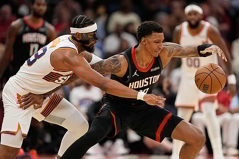 Phoenix Suns' Jordan Goodwin, left, reaches to knock the ball away from Houston Rockets' Jabari Smith Jr. during the first half of an NBA basketball game in Houston.