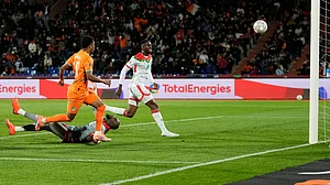 AP/Themba Hadebe : Ivory Coast's Amad Diallo, left, scores his sides first goal past Burkina Faso's Issoufou Dayo, right, and Burkina Faso's goalkeeper Kouakou Herve Koffi.