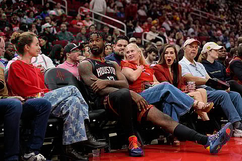 Houston Rockets forward Tari Eason (17) sits with fans during an extended officials timeout in the first half of an NBA basketball game against the Phoenix Suns in Houston.