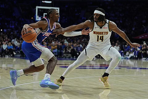 Philadelphia 76ers' Tyrese Maxey, left, tries to get a shot past Denver Nuggets' Daron Holmes II during the first half of an NBA basketball game in Philadelphia. 