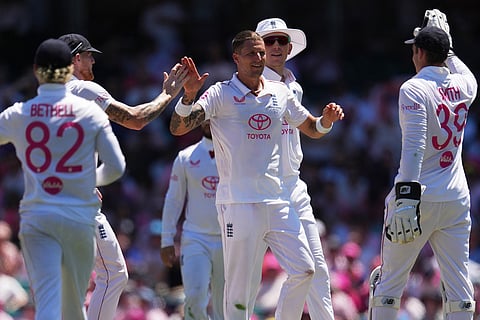 England's Brydon Carse, centre, is congratulated by teammates after taking the wicket of Australia Usman Khawaja during play on day three of the fifth and final Ashes cricket test between England and Australia in Sydney.