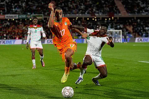 Burkina Faso's Ismahila Ouedraogo, right, challenges Ivory Coast's Guela Doue during the Africa Cup of Nations best of 16 soccer match between Ivory Coast and Burkina Faso in Marrakech, Morocco.
