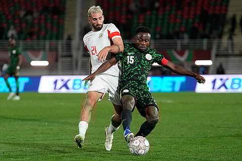 Mozambique's Guima, left, and Nigeria's Moses Simon challenge for the ball during the Africa Cup of Nations round of 16 soccer match between Nigeria and Mozambique in Fez, Morocco.