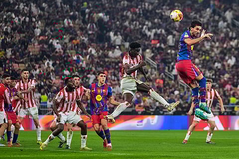 Barcelona's Ferran Torres, right, heads the ball during the Spanish Super Cup semifinal soccer match against Athletic Club Bilbao at King Abdullah Sports City Stadium in Jeddah, Saudi Arabia.
