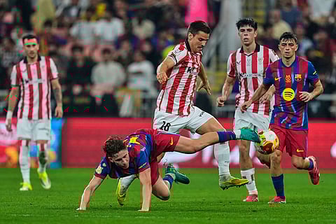 Barcelona's Fermin Lopez, foreground, duels for the ball with Athletic Bilbao's Mikel Jauregizar during the Spanish Super Cup semifinal soccer match at King Abdullah Sports City Stadium in Jeddah, Saudi Arabia.