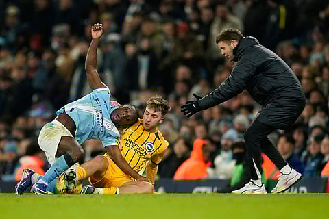 Brighton's head coach Fabian Huerzeler, right, gestures as Manchester City's Jeremy Doku, left, is tackled by Brighton's Jack Hinshelwood during the English Premier League soccer match between Manchester City and Brighton and Hove Albion in Manchester, England.