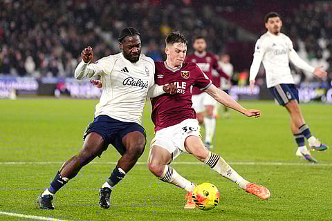 Nottingham Forest's Ola Aina, left, and West Ham United's Oliver Scarles in action during the English Premier League soccer match between West Ham United and Nottingham Forest in London.