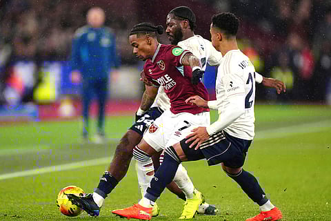 West Ham United's Crysencio Summerville battles for the ball with Nottingham Forest's Ola Aina and Omari Hutchinson, front, during the English Premier League soccer match between West Ham United and Nottingham Forest in London.