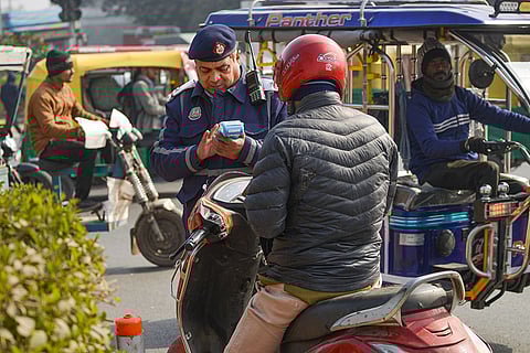 A traffic police official issues a 'challan' to a rider, in New Delhi. The registration of FIRs against motorists for wrong-side driving will be a 'selective' measure rather than a blanket policy, with criminal action reserved as a last resort, a senior official with the Delhi Traffic Police said on Wednesday. 