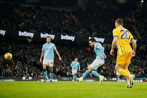 Manchester City's Rayan Cherki, center, attempts a shot at goal and misses during the English Premier League soccer match between Manchester City and Brighton and Hove Albion in Manchester, England.