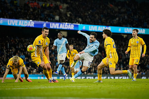Manchester City's Rayan Cherki, third right, attempts a shot at goal in front of Brighton's Lewis Dunk during the English Premier League soccer match between Manchester City and Brighton and Hove Albion in Manchester, England.