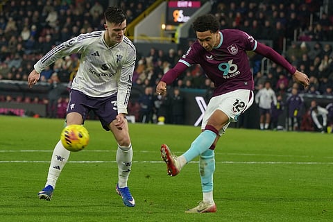 Burnley's Bashir Humphreys clears the ball in front of Manchester United's Benjamin Sesko during the Premier League soccer match between Burnley and Manchester United in Burnley, England.