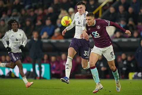 Manchester United's Benjamin Sesko, left, and Burnley's Maxime Esteve fight for the ball during the Premier League soccer match between Burnley and Manchester United in Burnley, England.