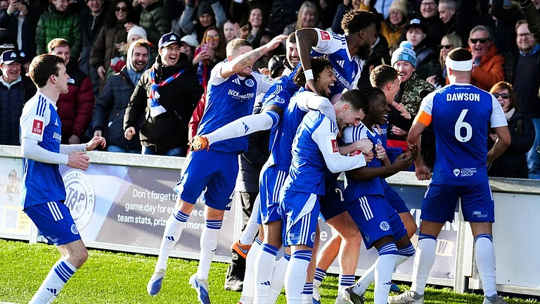 Macclesfield Town's Isaac Buckley-Ricketts celebrates scoring his side's second goal with teammates, during the FA Cup third-round match between Macclesfield Town and Crystal Palace. - Martin Rickett/PA via AP