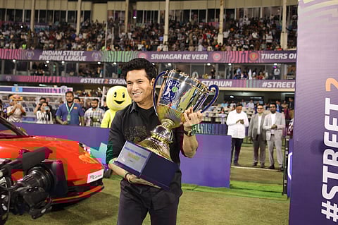 Sachin Tendulkar carries the ISPL trophy during the opening ceremony