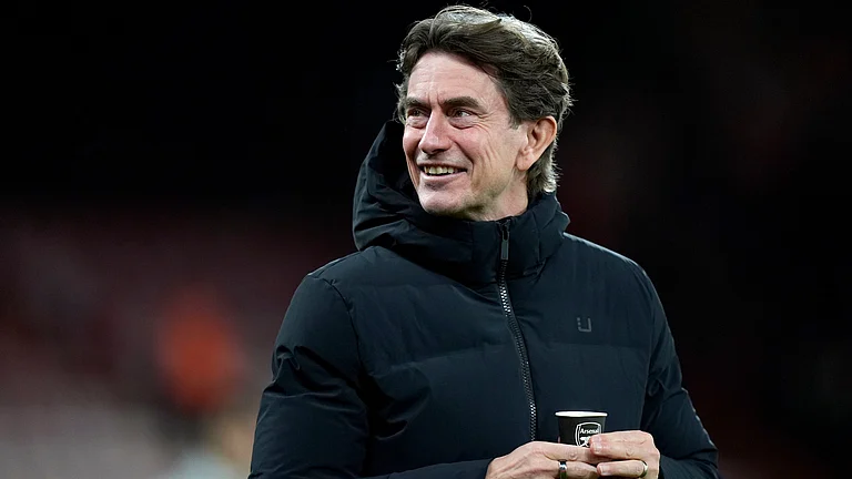 Tottenham Hotspur manager Thomas Frank holds a coffee cup bearing the Arsenal logo as he walks on the pitch before the English Premier League soccer match between Bournemouth and Tottenham Hotspur in Bournemouth, England, Wednesday Jan. 7, 2026. - | Photo: PA/Andrew Matthews via AP