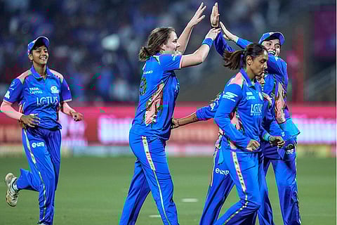 Mumbai Indians’ Nat Sciver-Brunt, second left, celebrates with teammates after taking the wicket of Royal Challengers Bengaluru’s Grace Harris during a Women's Premier League (WPL) T20 cricket match between Mumbai Indians and Royal Challengers Bengaluru, at the DY Patil Stadium, in Navi Mumbai.