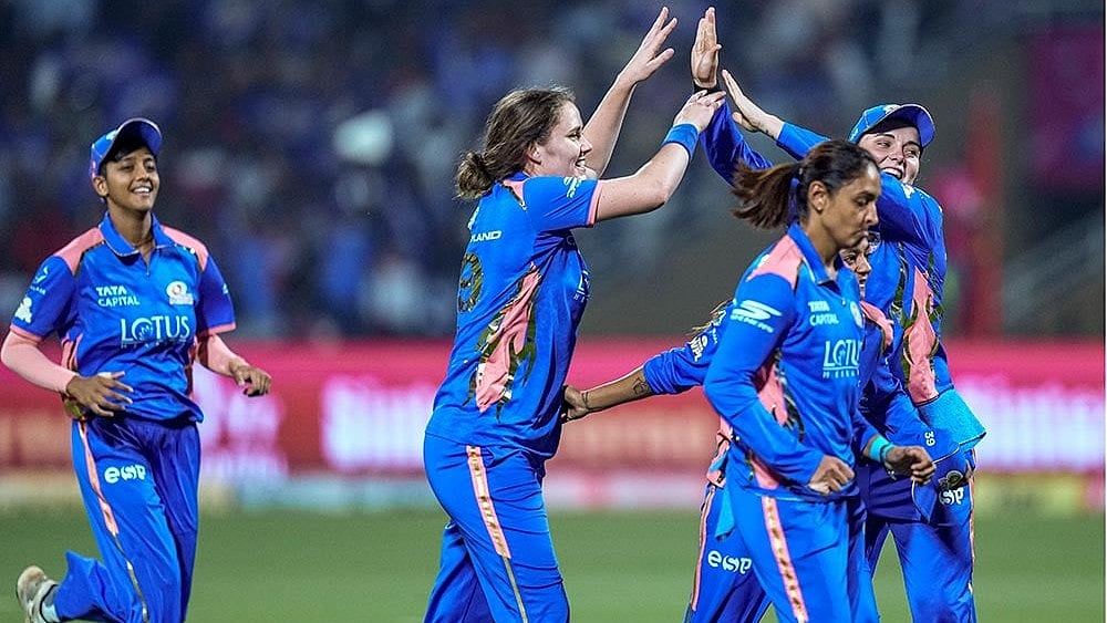 Mumbai Indians’ Nat Sciver-Brunt, second left, celebrates with teammates after taking the wicket of Royal Challengers Bengaluru’s Grace Harris during a Women's Premier League (WPL) T20 cricket match between Mumbai Indians and Royal Challengers Bengaluru, at the DY Patil Stadium, in Navi Mumbai. - | Photo: PTI/Kunal Patil