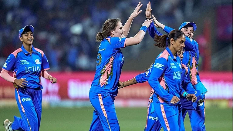 Mumbai Indians’ Nat Sciver-Brunt, second left, celebrates with teammates after taking the wicket of Royal Challengers Bengaluru’s Grace Harris during a Women's Premier League (WPL) T20 cricket match between Mumbai Indians and Royal Challengers Bengaluru, at the DY Patil Stadium, in Navi Mumbai. - | Photo: PTI/Kunal Patil