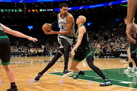 San Antonio Spurs forward Victor Wembanyama (1) drives to the basket against Boston Celtics guard Derrick White (9) during the second half of an NBA basketball game in Boston.