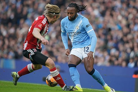 Manchester City's Antoine Semeny, right, and Exeter's Ilmari Niskanen fight for the ball during the FA Cup third round match between Manchetster City and Exeter in Manchester, England.