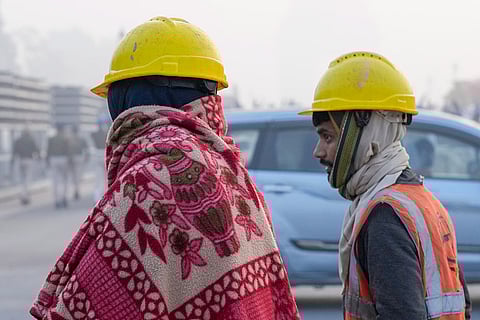 Construction workers at a site on a cold winter morning, at Kartavya Path, in New Delhi.