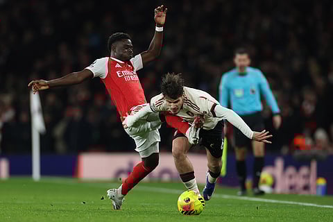 Arsenal's Bukayo Saka fouls Liverpool's Milos Kerkez during the English Premier League soccer match between Arsenal and Liverpool in London.