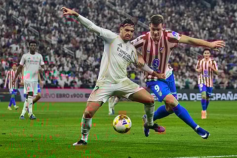 Real Madrid's Raul Asencio, left, duels for the ball with Atletico Madrid's Alexander Sorloth during the Spanish Super Cup semifinal soccer match at King Abdullah Sports City Stadium in Jeddah, Saudi Arabia.