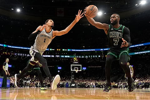 Boston Celtics guard Jaylen Brown (7) grabs a defensive rebound against San Antonio Spurs forward Victor Wembanyama (1) during the second half of an NBA basketball game in Boston.