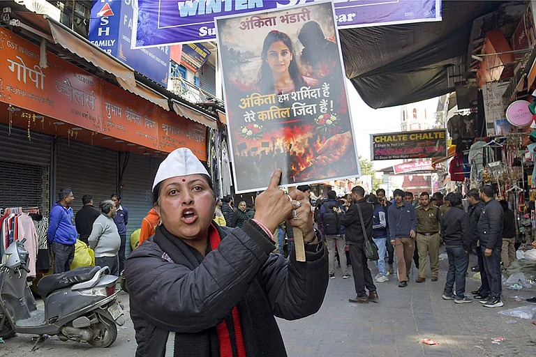 A protester holds a placard during a statewide bandh called by social groups and political organisations over the Ankita Bhandari murder case, in Dehradun. - | Photo: PTI