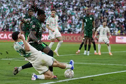 Algeria's Ibrahim Maza, front, tries to block a shot from Nigeria's Calvin Bassey during the Africa Cup of Nations quarterfinal soccer match between Nigeria and Algeria, in Marrakech, Morocco.