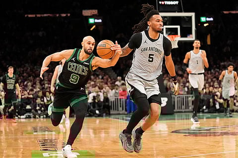 Boston Celtics guard Derrick White (9) steals the ball from San Antonio Spurs guard Stephon Castle (5) during the second half of an NBA basketball game in Boston.