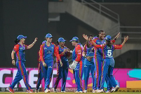 Delhi Capitals’ Chinelle Henry celebrates with teammates after taking the wicket of Mumbai Indians' Amelia Kerr during a Women's Premier League (WPL) T20 cricket match between Mumbai Indians and Delhi Capitals, at the DY Patil Stadium, in Navi Mumbai.